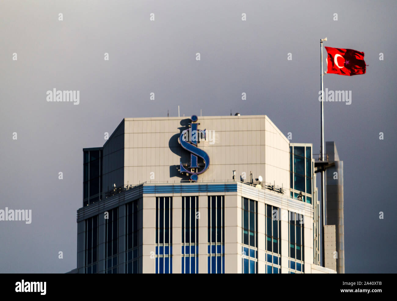 Close up of the logo of Isbank with a Turkish flag at the rooftop of tallest building of Is Towers Complex. Stock Photo