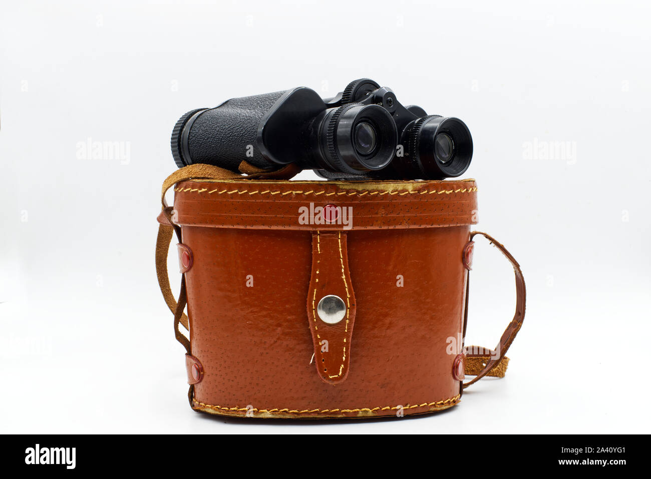Ancient binoculars with its leather bag cover, isolated on white