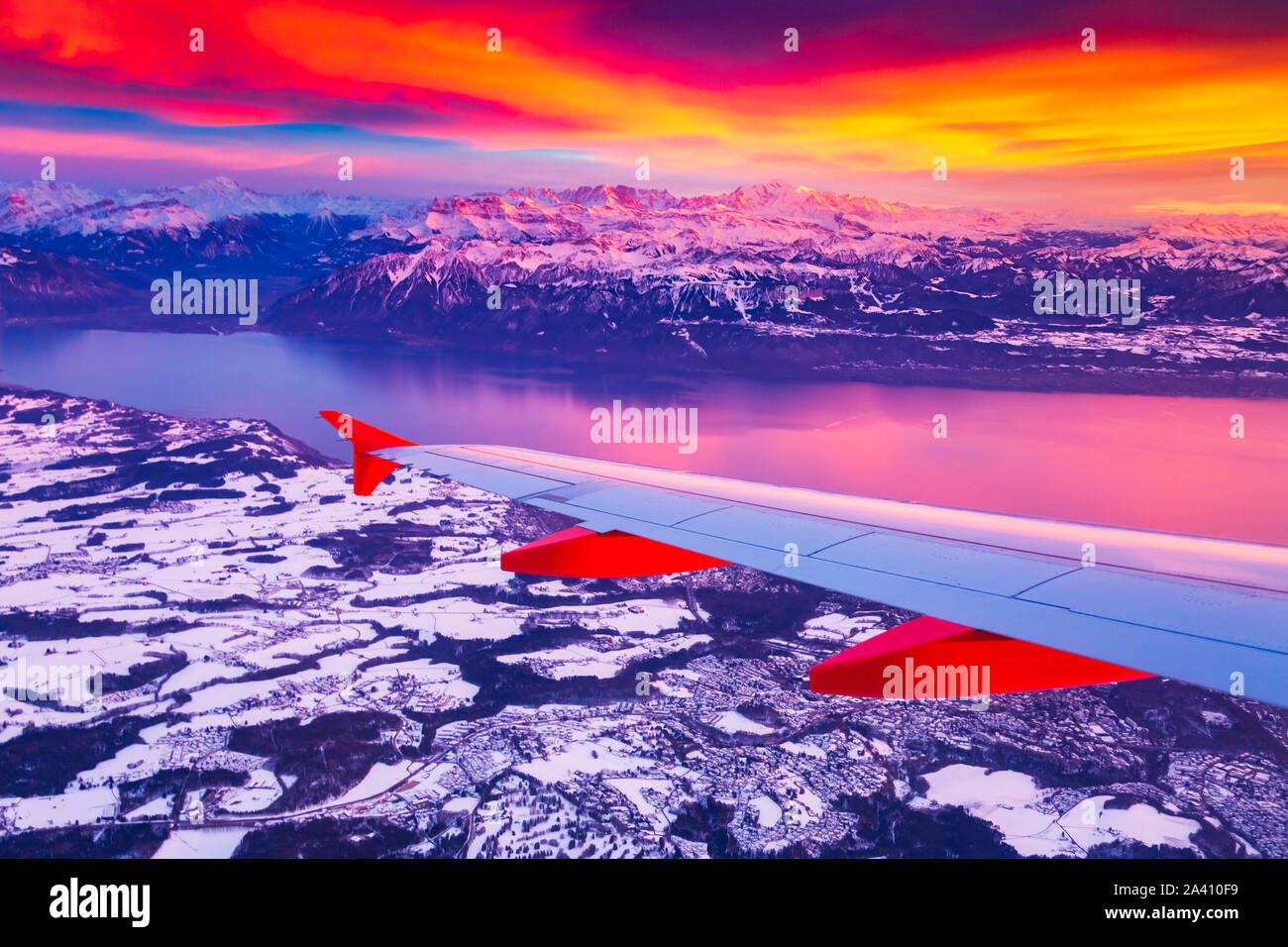 Amazing view from the airplane window during the sunset over mountains in Switzerland Stock Photo