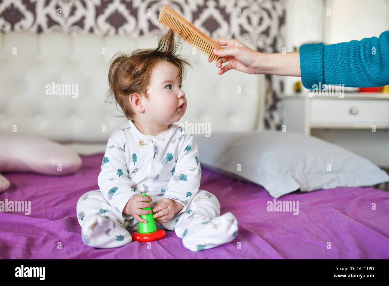 mom combes a small child. mother hand brushing with a comb his adorable baby  hair, Mom taking care of infant  focus Stock Photo - Alamy