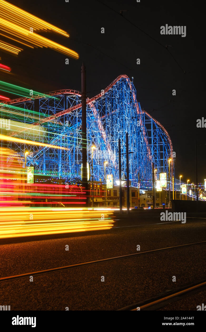 The streaked lights of an illuminated Blackpool Tram pass ing The