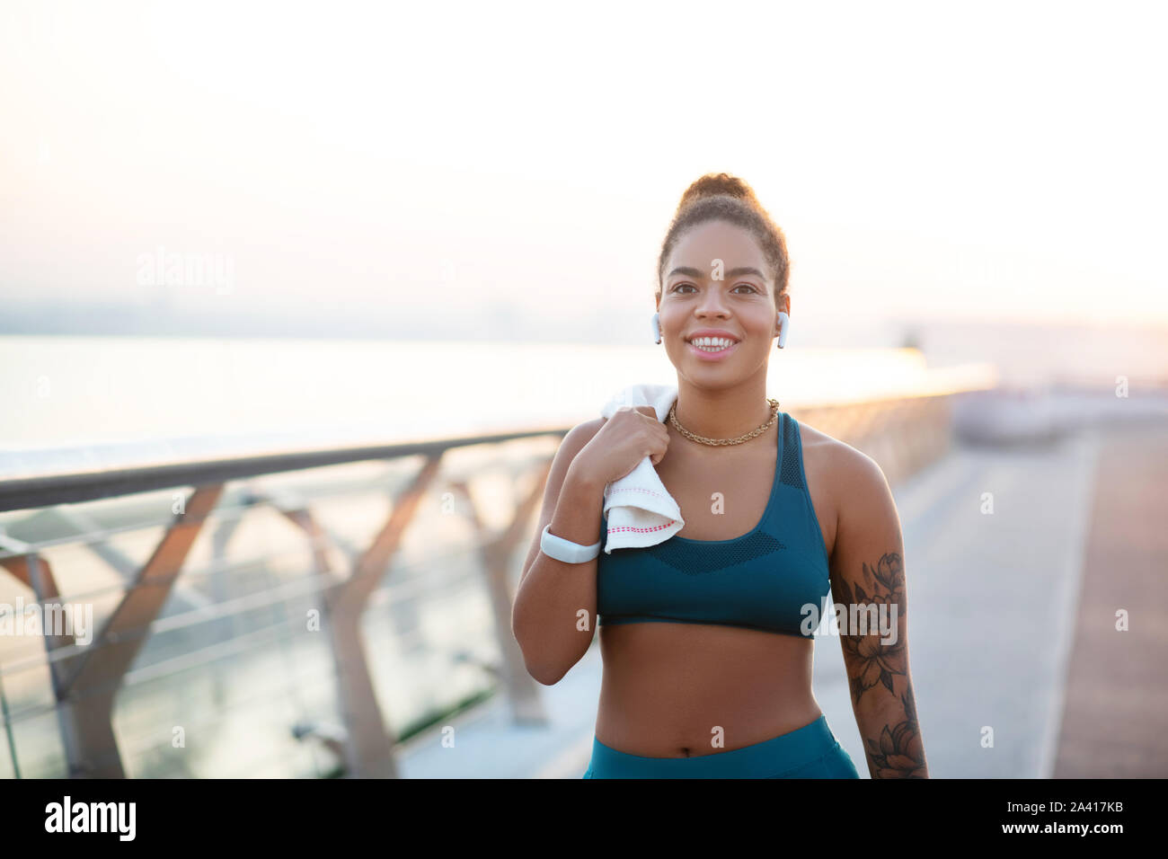 Beaming woman holding towel while walking after run Stock Photo