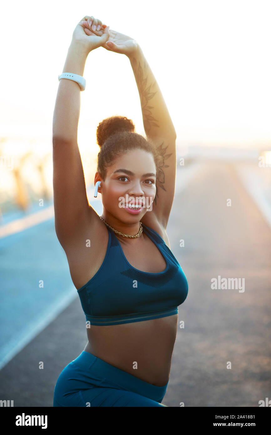 Dark-eyed woman stretching her body before starting workout Stock Photo