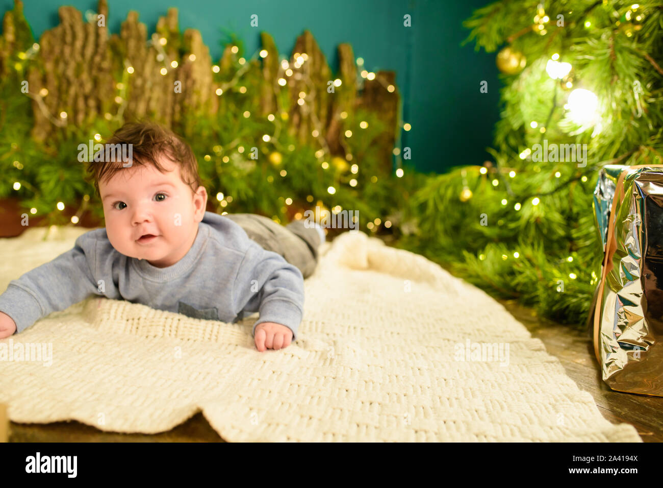 A child near the Christmas tree. Little boy celebrating christmas. baby's first christmas. Stock Photo