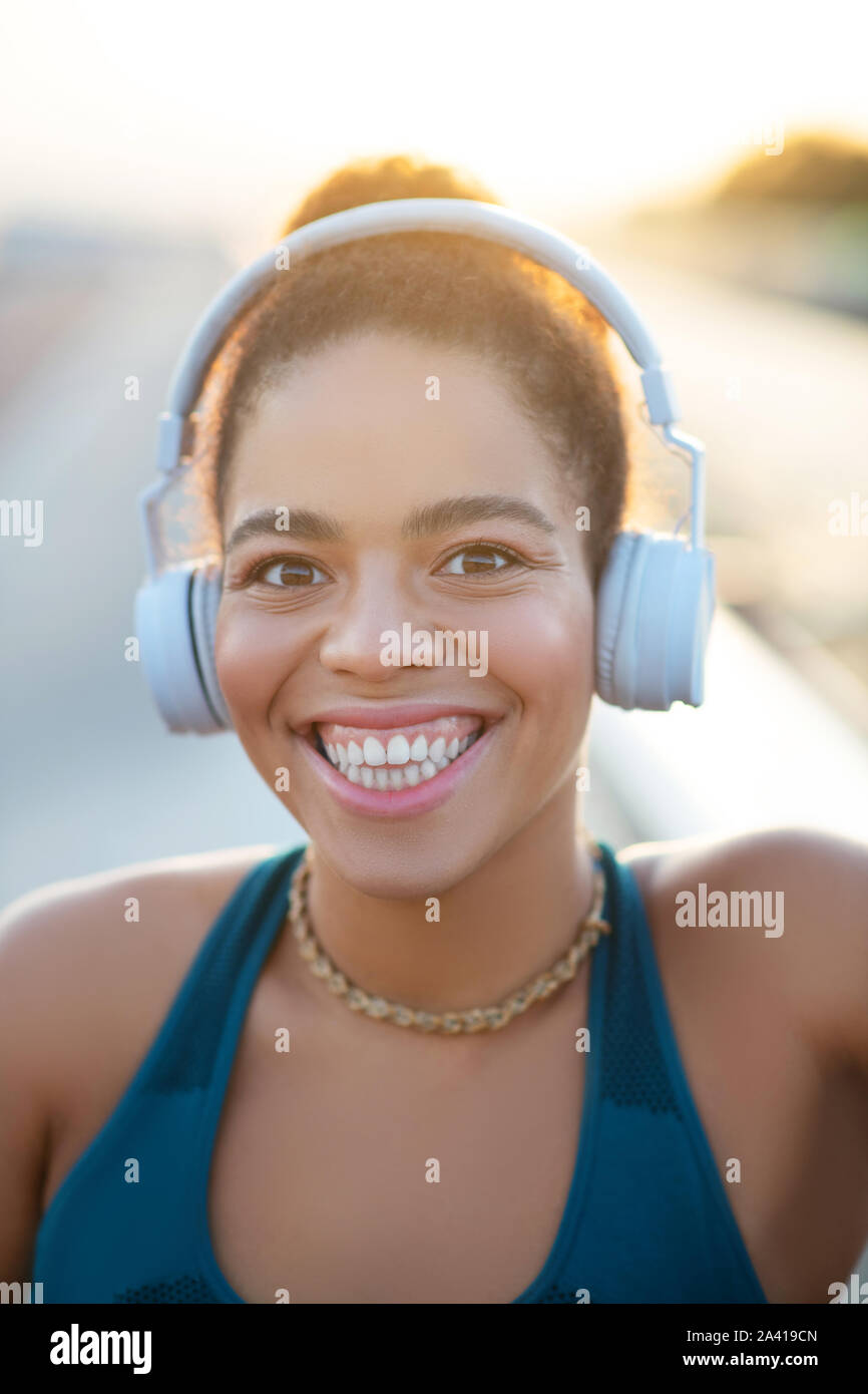 Dark-eyed woman showing toothy smile after running Stock Photo