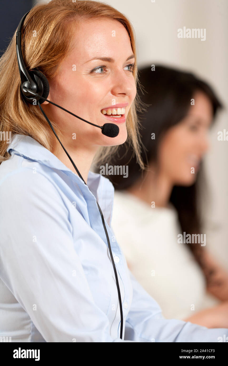 Two colleagues working in a busy call centre office. Stock Photo