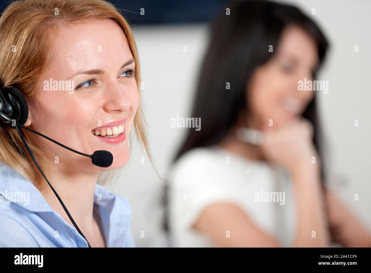 Two colleagues working in a busy call centre office. Stock Photo