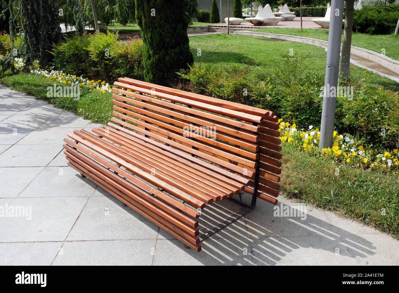 Beautiful comfortable wooden bench of brown slats with a smooth transition.  Arrangement of the park comfortable places for recreation, a large wooden  Stock Photo - Alamy