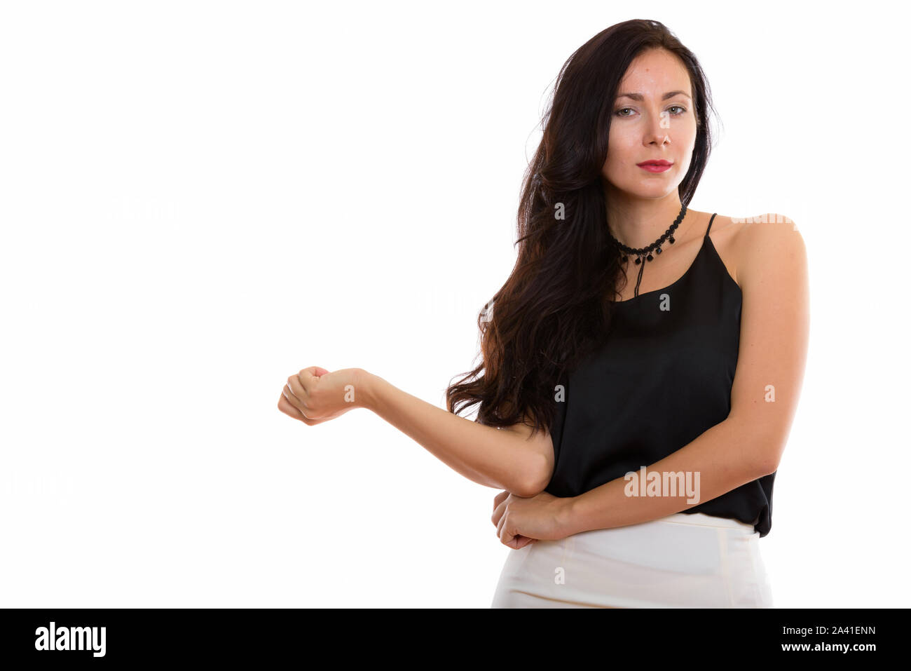 Studio shot of young beautiful businesswoman with arm resting on Stock Photo