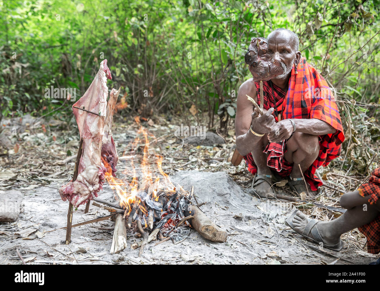 Arusha, Tanzania, 7Th September 2019 Maasai man cooking meat on fire