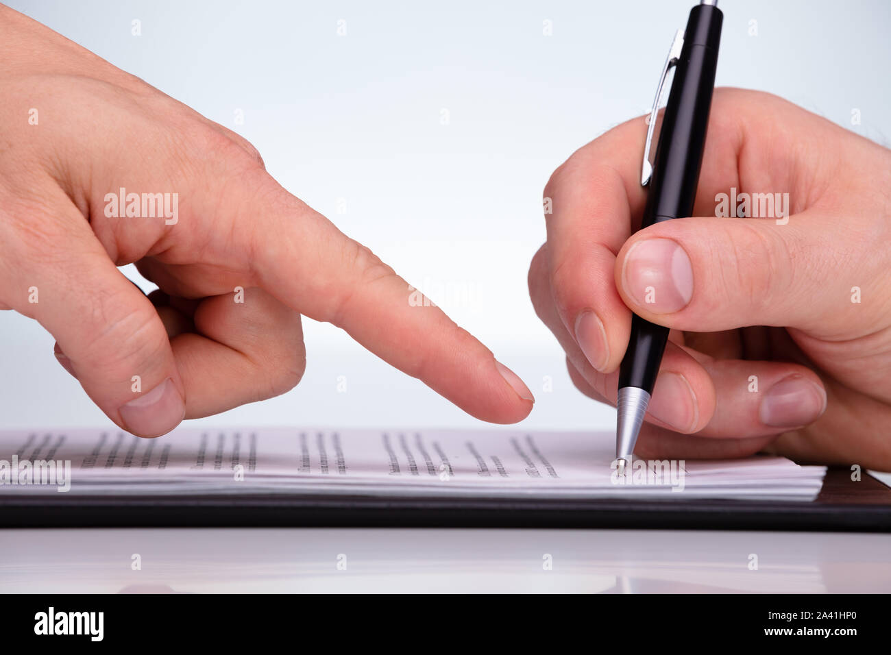 Close-up Of A Person Letting The Customer To Sign The Contract With Pen On Paper Stock Photo