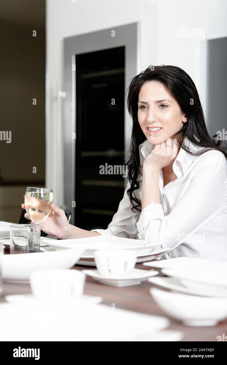 Attractive elegant woman enjoying a meal at the dinner table. Stock Photo