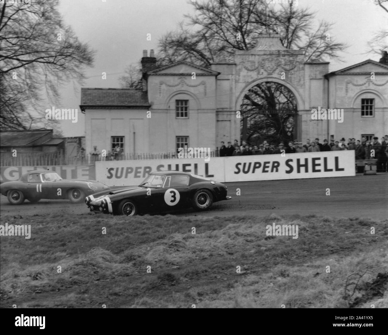 Ferrari 250 SWB spins as Jaguar E type passes. Stock Photo