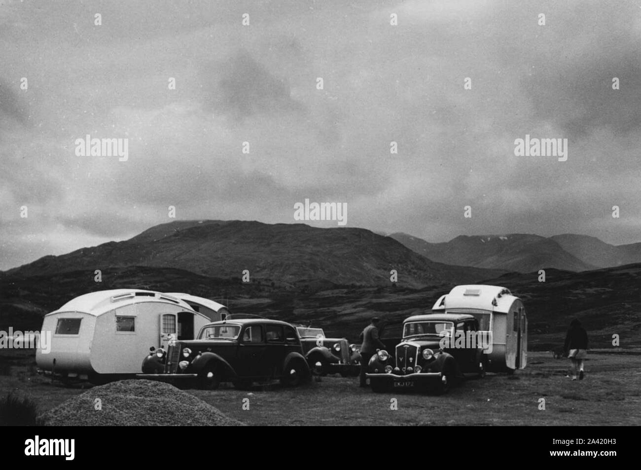 Group of cars and caravans camping in Scottish Highlands 1930's Stock