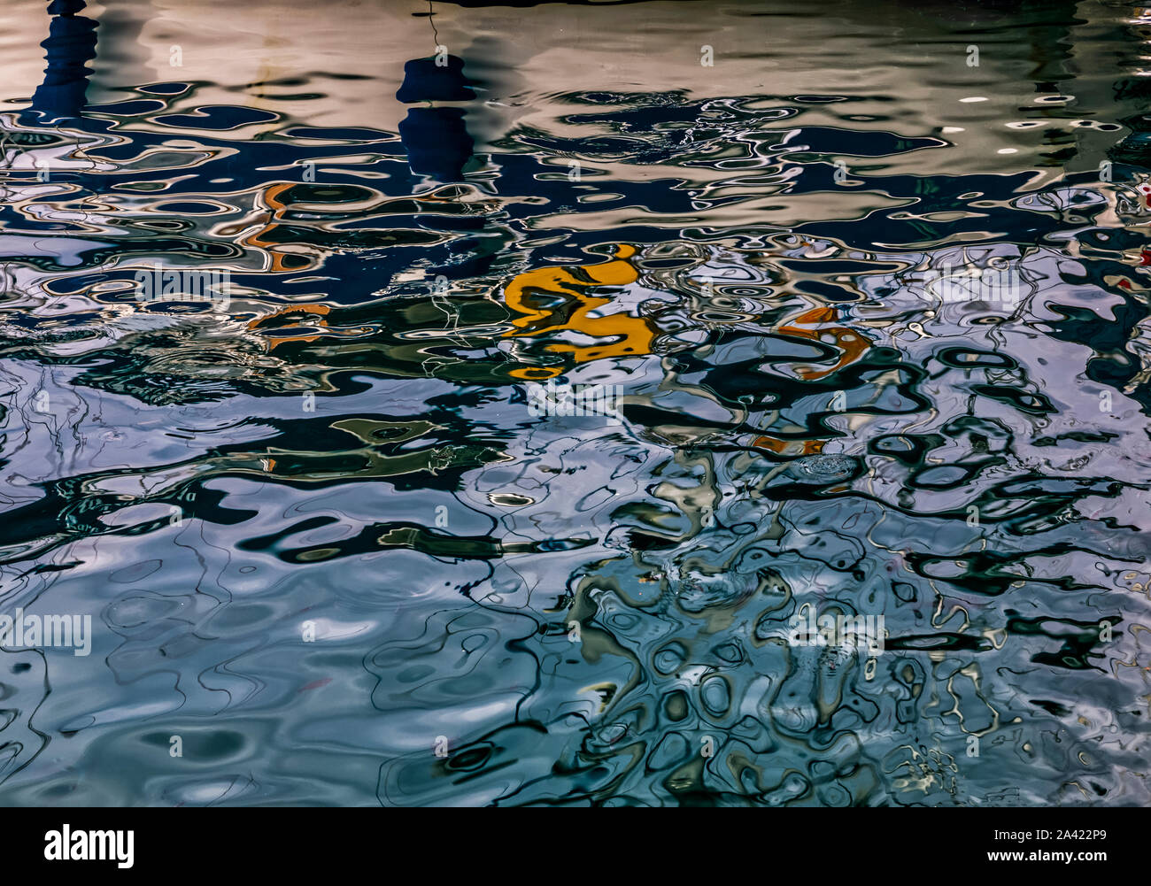 Surface of dark ripples on Aegean Sea . Interplay of dark blue, white, and orange reflections. Stock Image. Stock Photo
