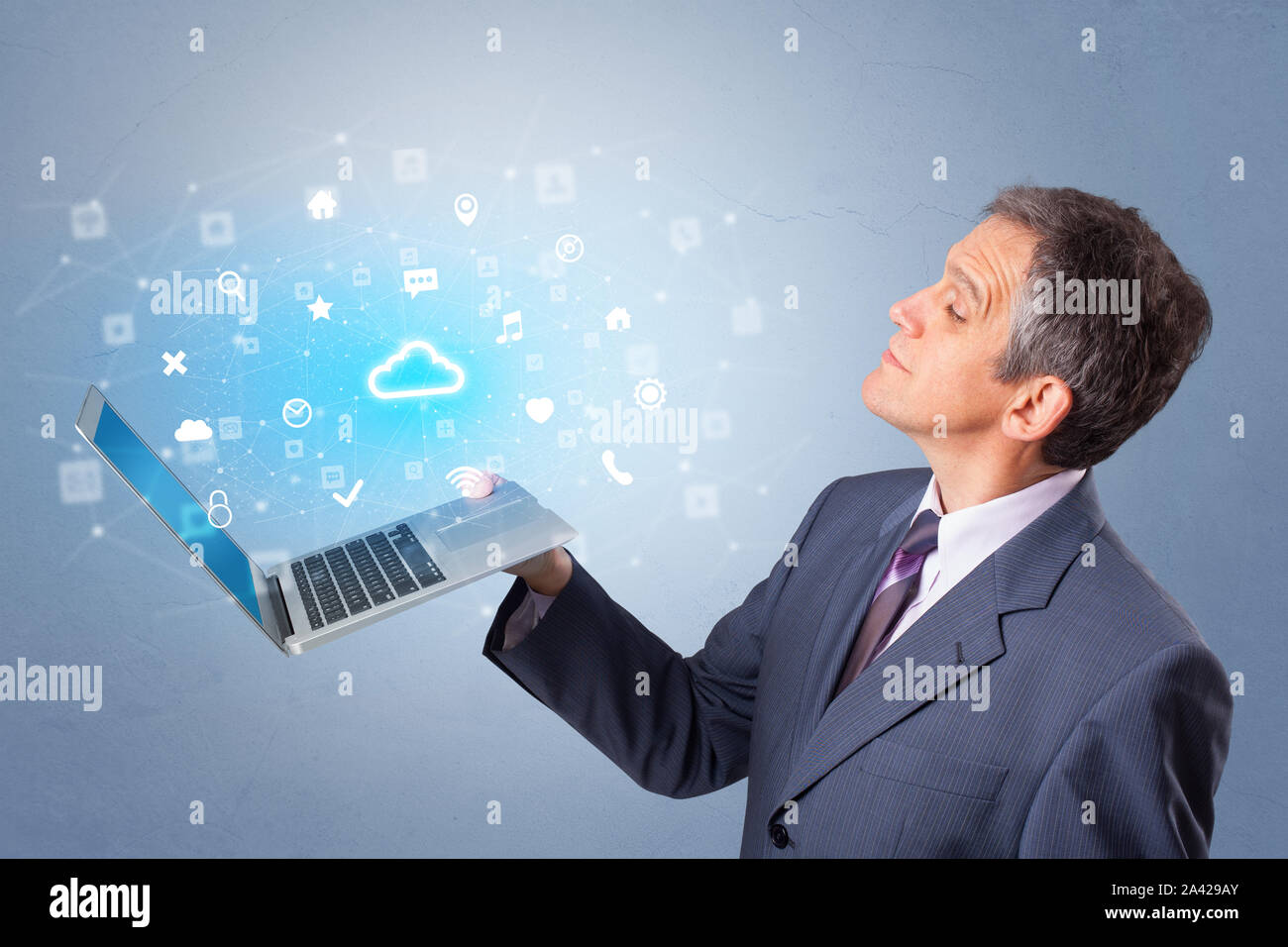 Man holding laptop projecting notifications, symbols and information based on cloud technology system Stock Photo