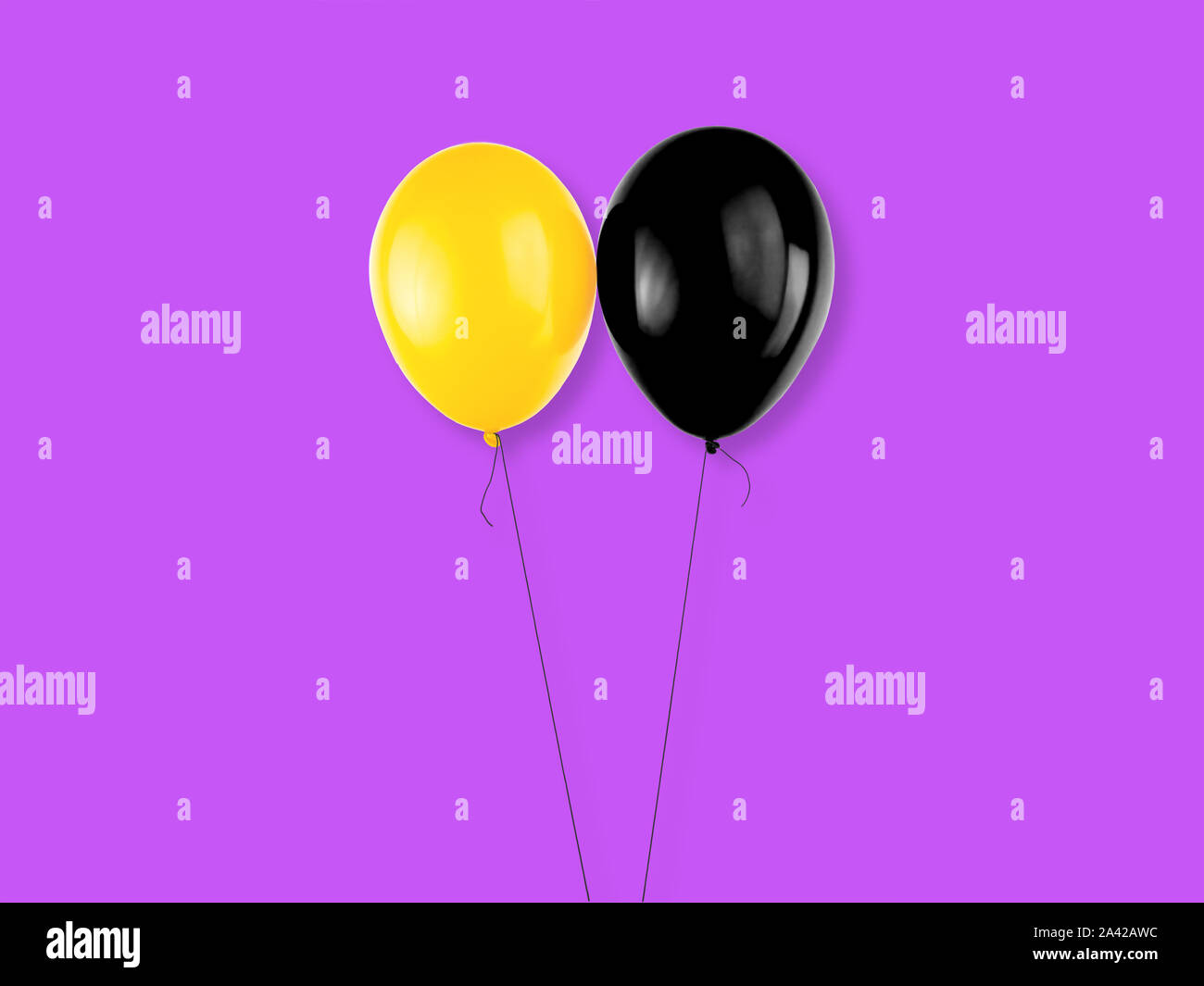 Yellow and black colored balloons on purple background. Halloween elements, text and copy space. Stock Photo