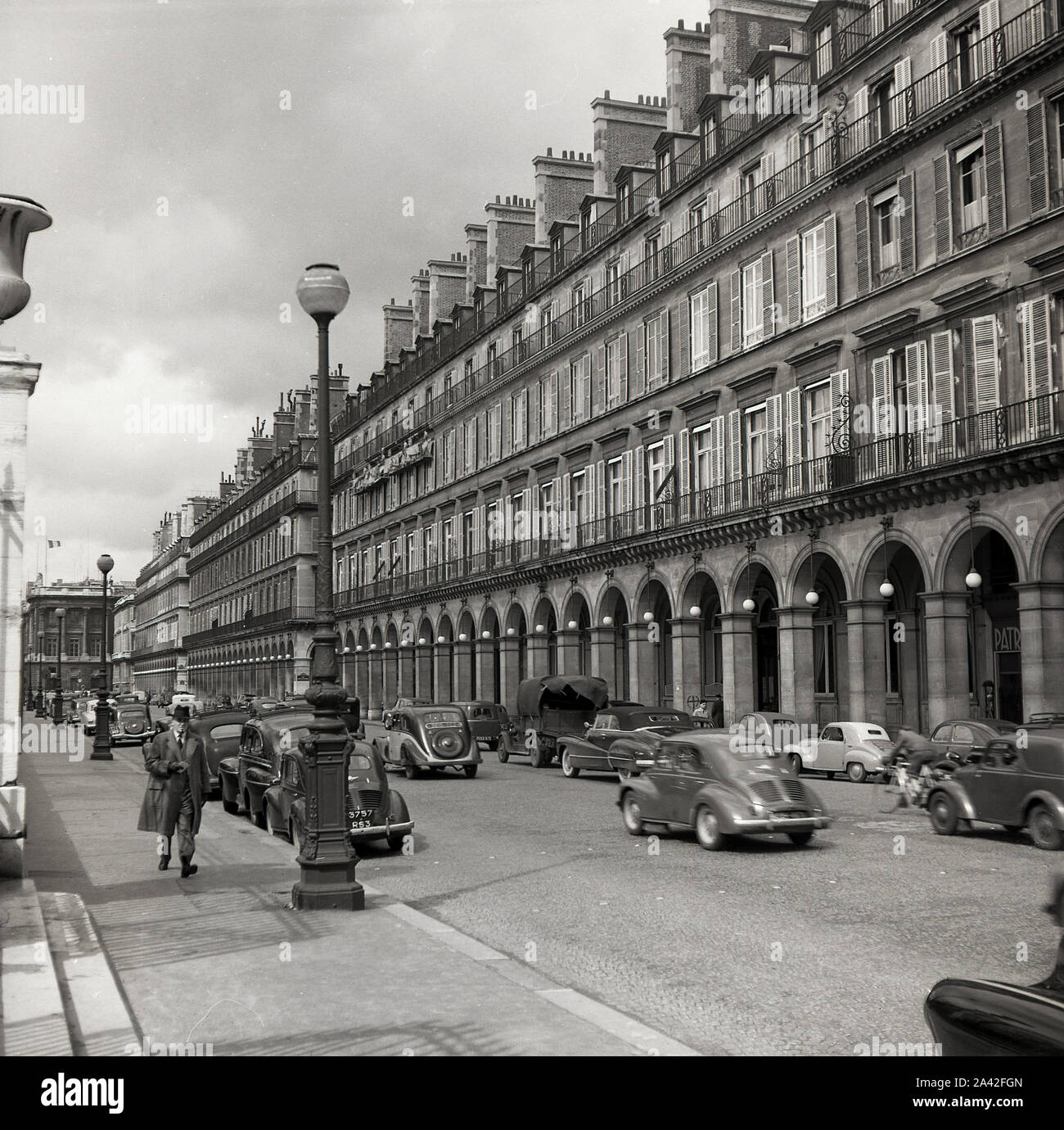 1950s, historical, motorcars of the era on the Rue de Rivoli, Paris, France, a famous street that runs along the north wing of the Louvre Palace and with its exterior arched facade at ground level. Stock Photo