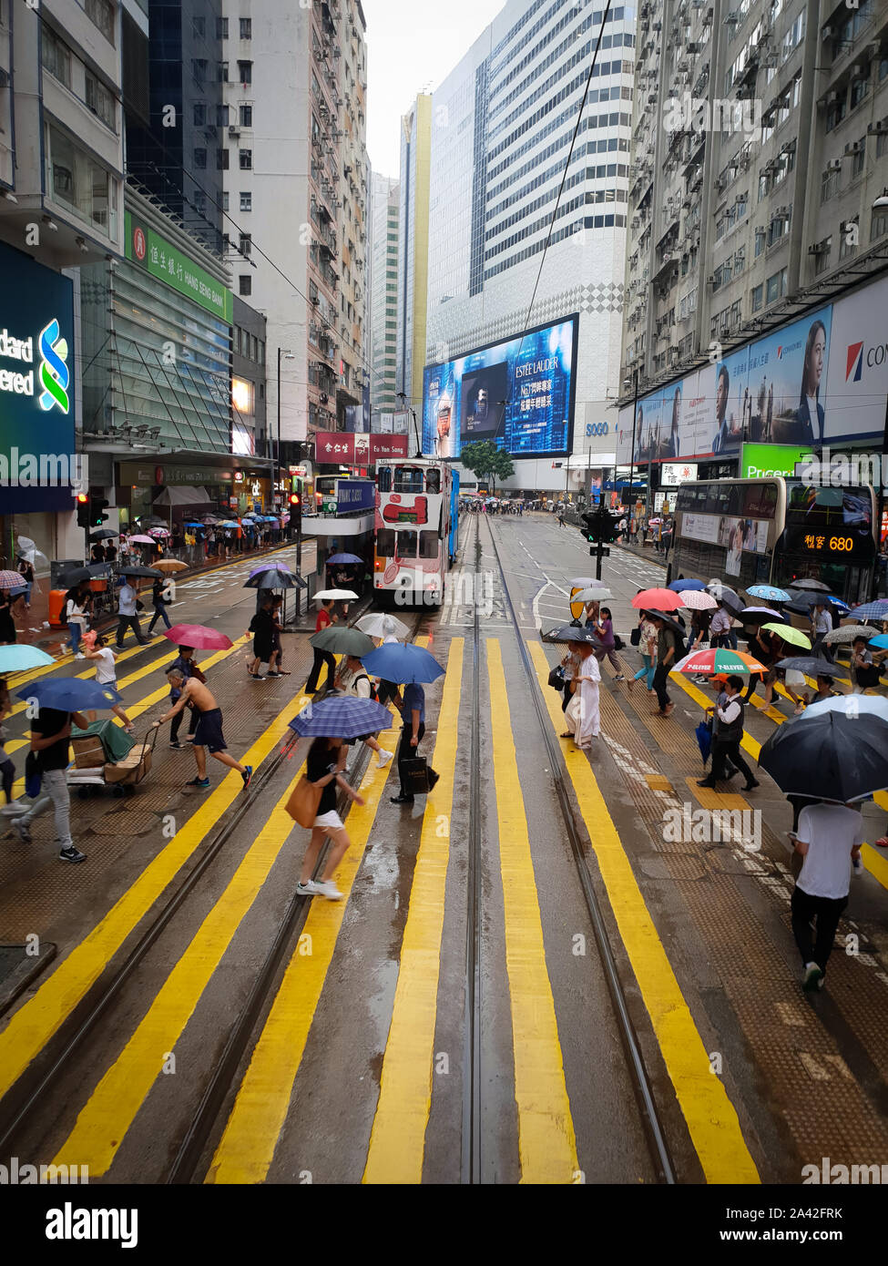 People are crossing the road in rain, Causeway Bay, Hong Kong SAR Stock Photo