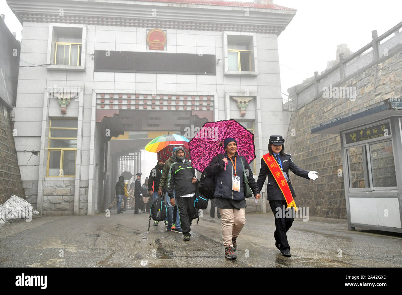 Lhasa, China's Tibet Autonomous Region. 20th June, 2019. A Chinese border control officer (1st R) leads a group of Indian pilgrims as they enter China from Nathu La Pass in Yadong County, southwest China's Tibet Autonomous Region, June 20, 2019. TO GO WITH 'China Focus: Pilgrimage boosts exchanges between China, India' Credit: Li Xin/Xinhua/Alamy Live News Stock Photo