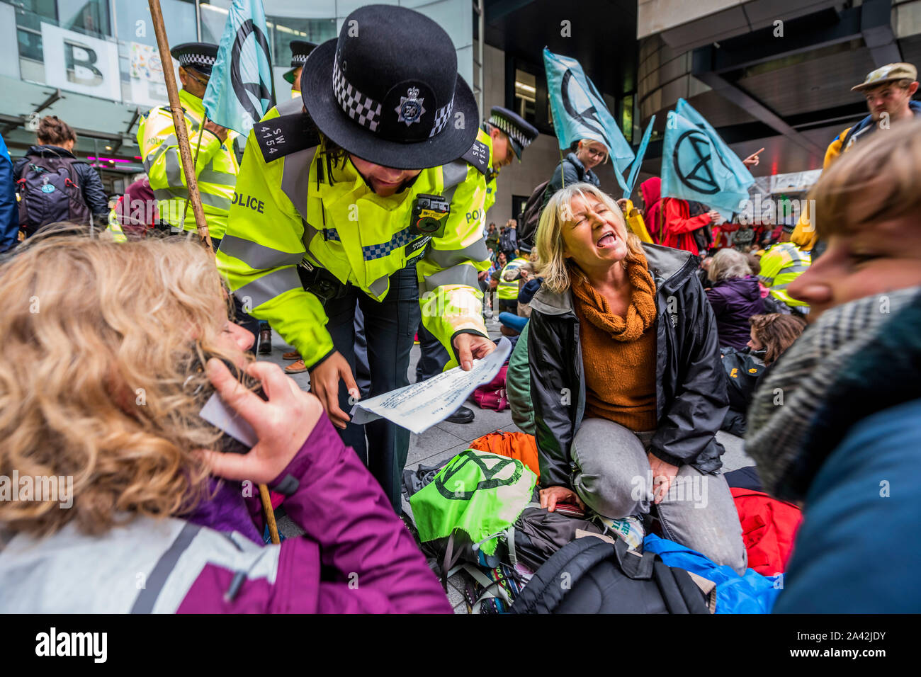 London, UK. 11th Oct 2019. Police warn protesters that they may be arrested under section 14 but they mostly ignore them or make noise to avoid hearing - XR Wales blockade the BBC Broadcasting House in Portland Place because they believe they have been slow to speak up on climate change - The fifth day of the Extinction Rebellion October action which has blocked roads in central London. They are again highlighting the climate emergency, with time running out to save the planet from a climate disaster. Credit: Guy Bell/Alamy Live News Stock Photo