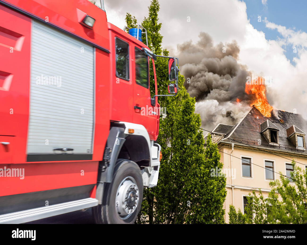 Fire service with burning house Stock Photo