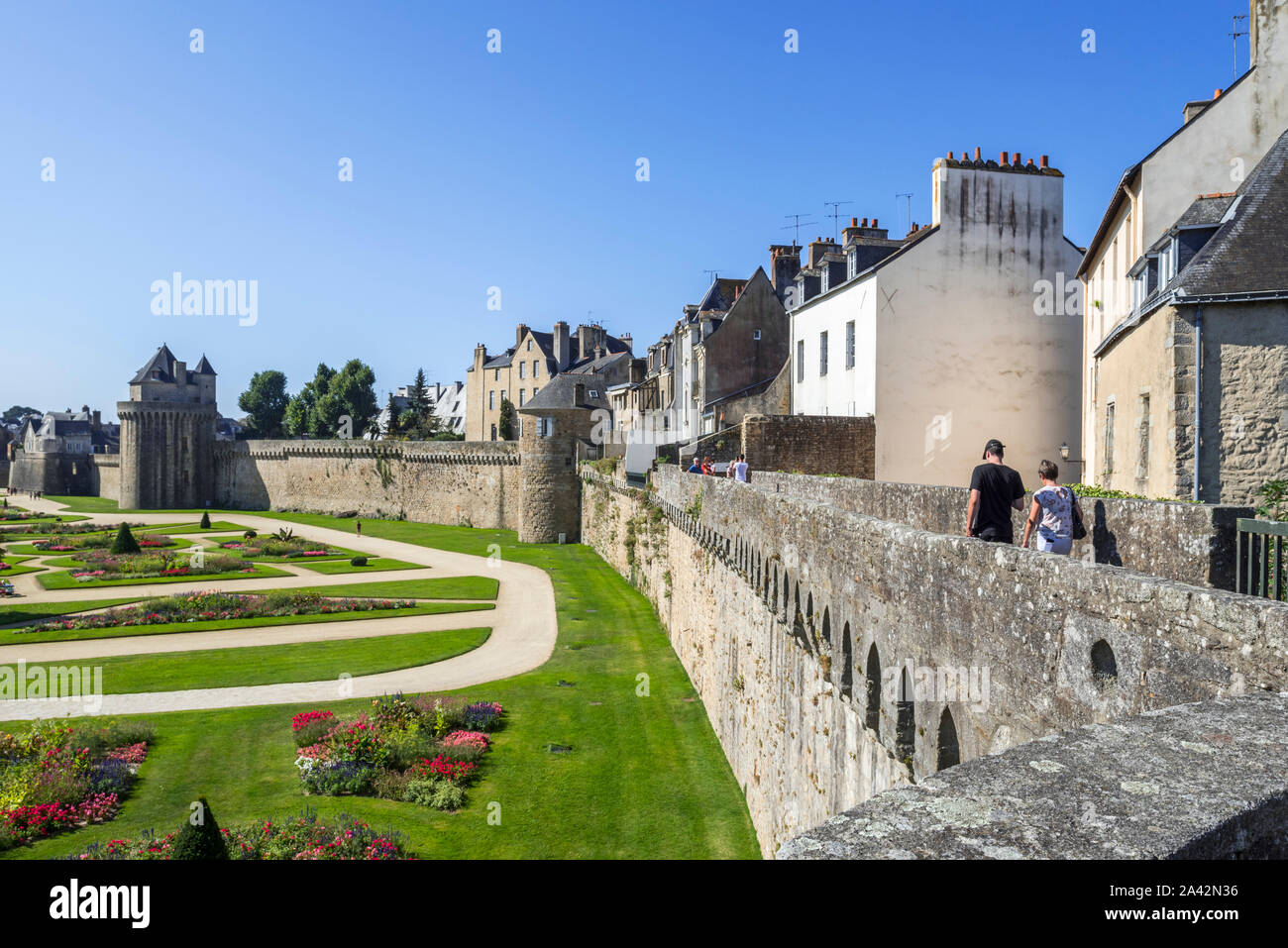 Garden of the Hermine castle / Jardin du Château de l'Hermine and tourists walking on the city walls of the town Vannes, Morbihan, Brittany, France Stock Photo