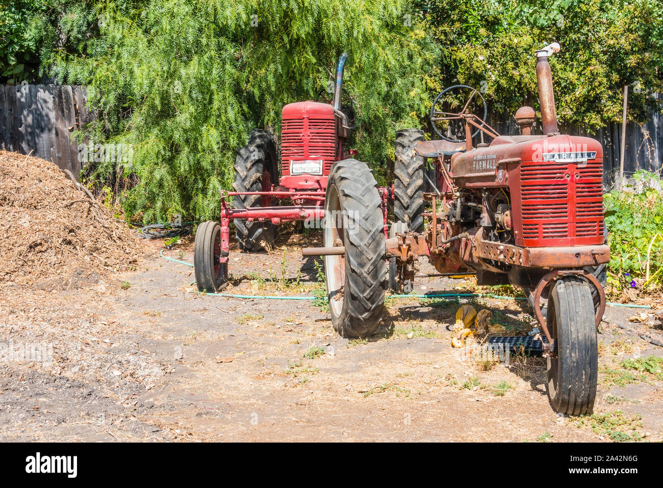 Two old red tractors parked in Los Olivos, California. Stock Photo