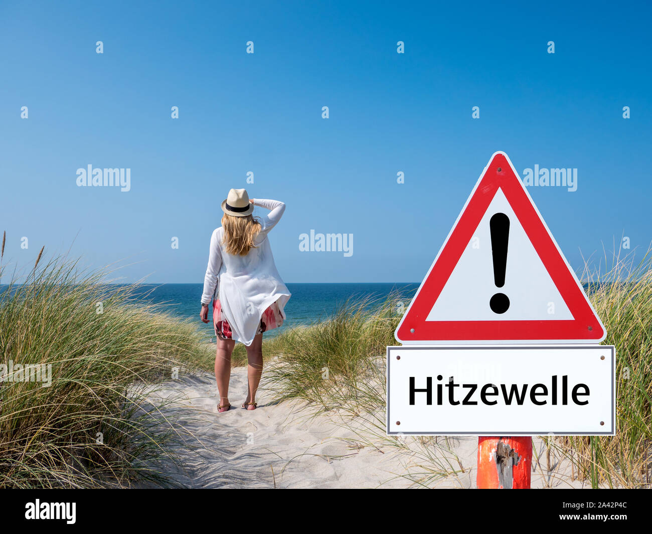 German Woman with warning sign heat wave Stock Photo