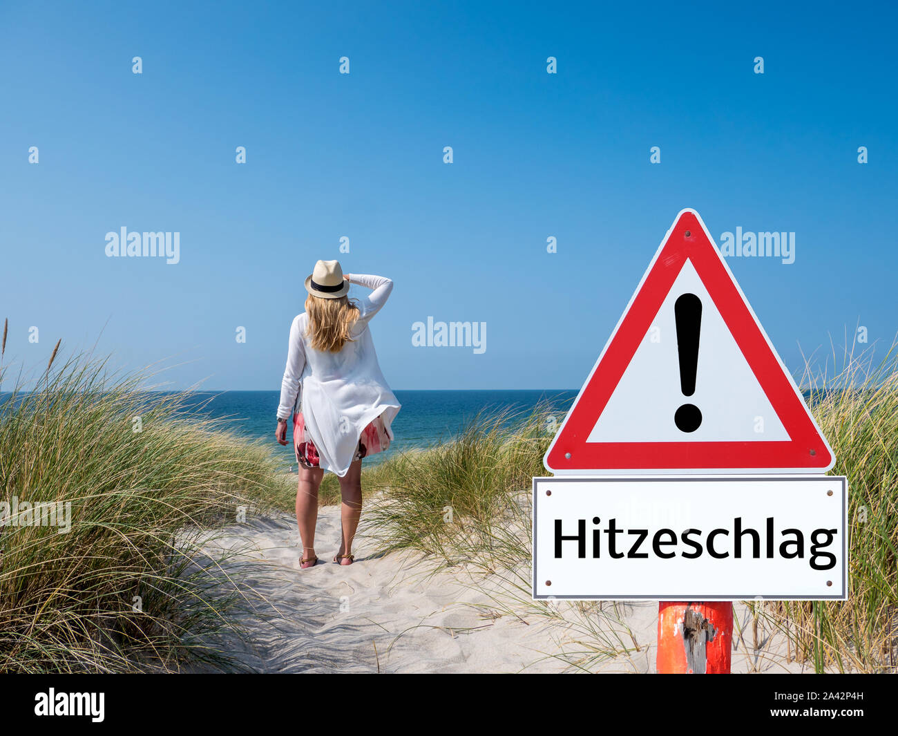 German Woman with warning sign heat stroke Stock Photo