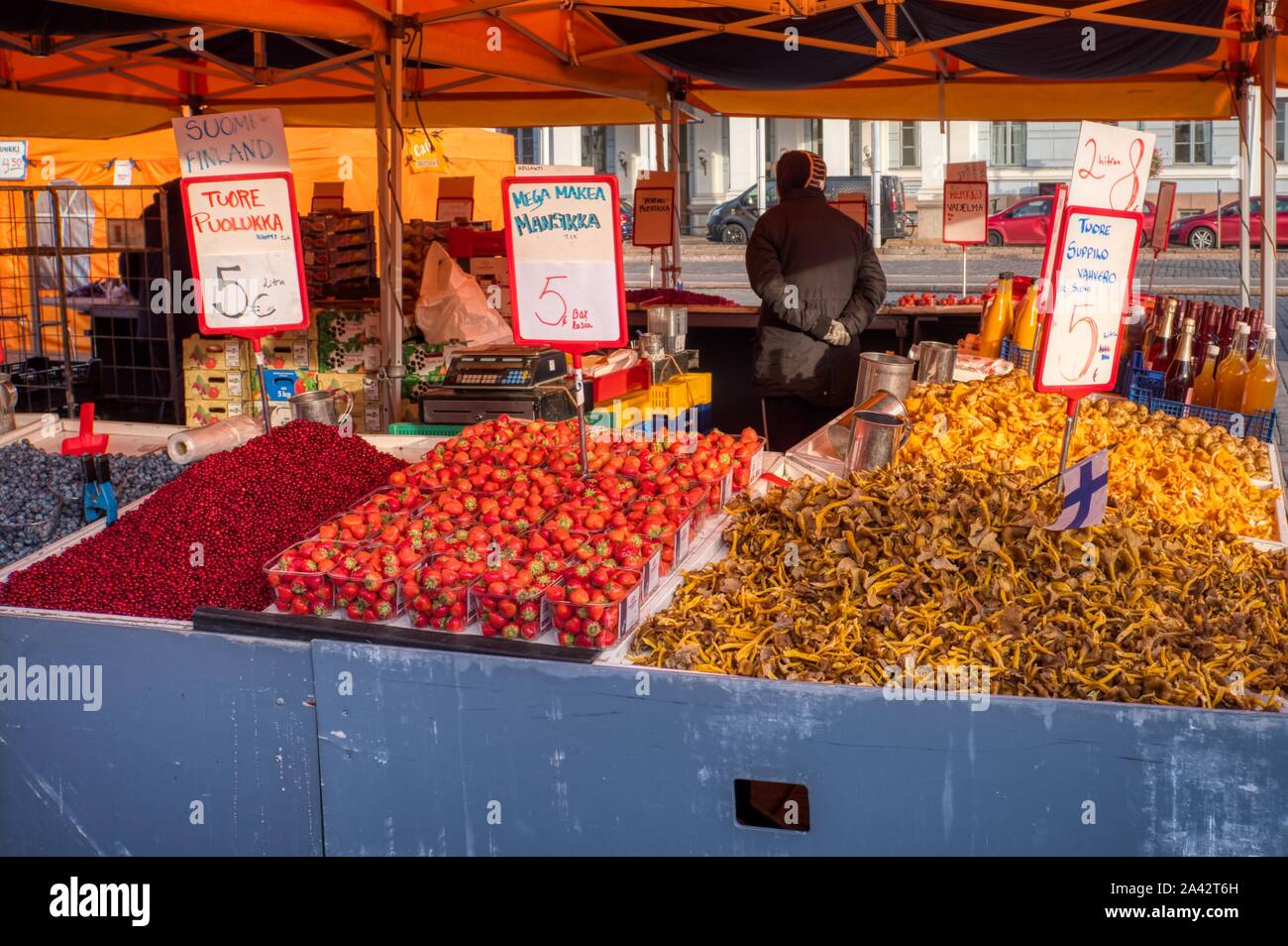 Fresh food. Lingonberries, strawberries and chanterelle mushrooms piled up on a market stall, Central Market, Helsinki, Finland Stock Photo