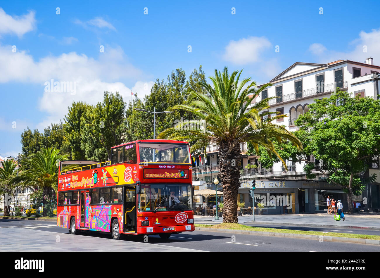 Funchal, Madeira, Portugal - Sep 10, 2019: Red double-decker tourist bus driving people around the Madeiran capital city. Hop on hop off buses, transport service. Tourist attraction. Vacation spot. Stock Photo