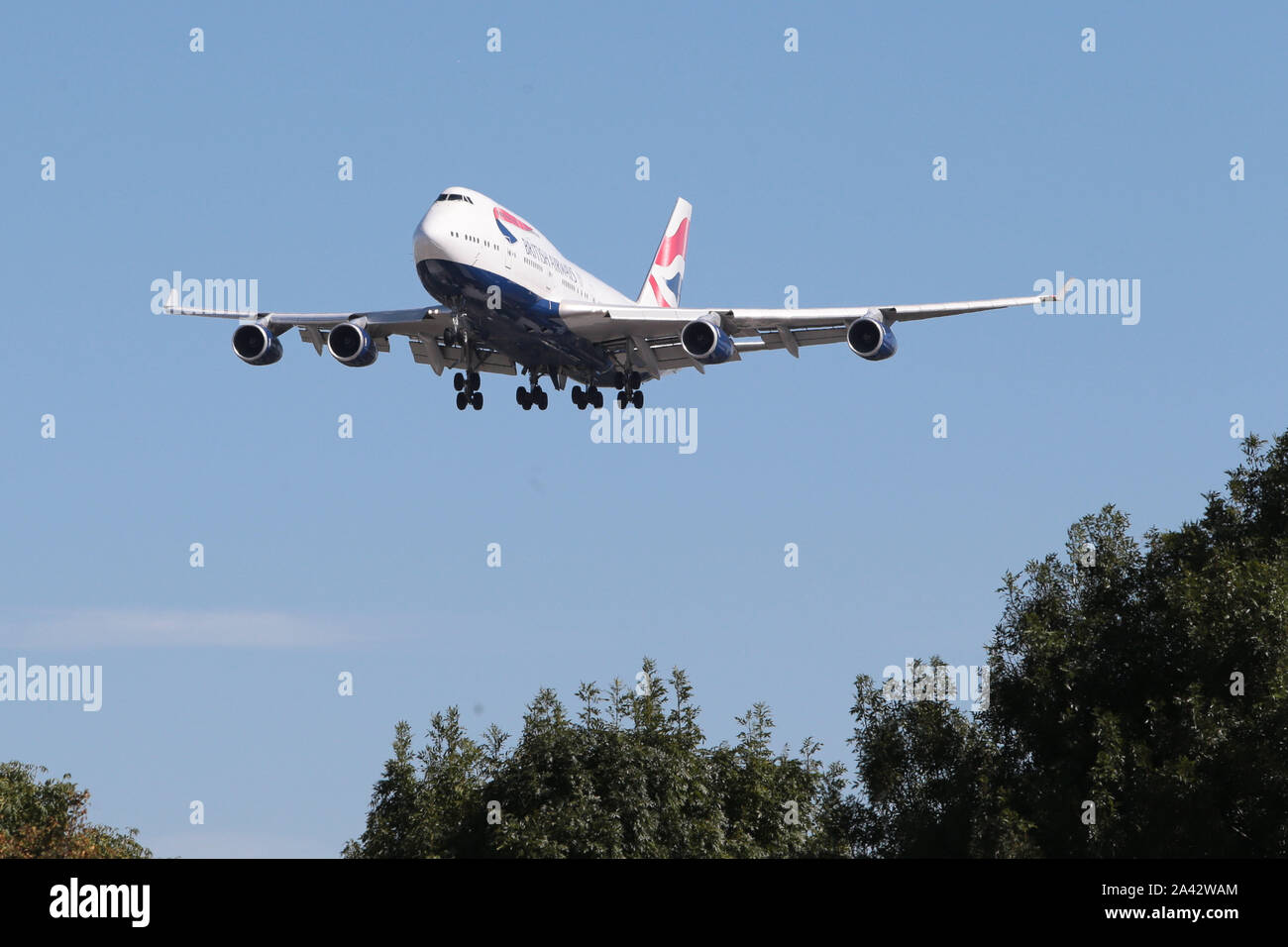 Coming out of the blue sky with under carraige coming down to land at London Heathrow Airport in the United Kingdom Stock Photo