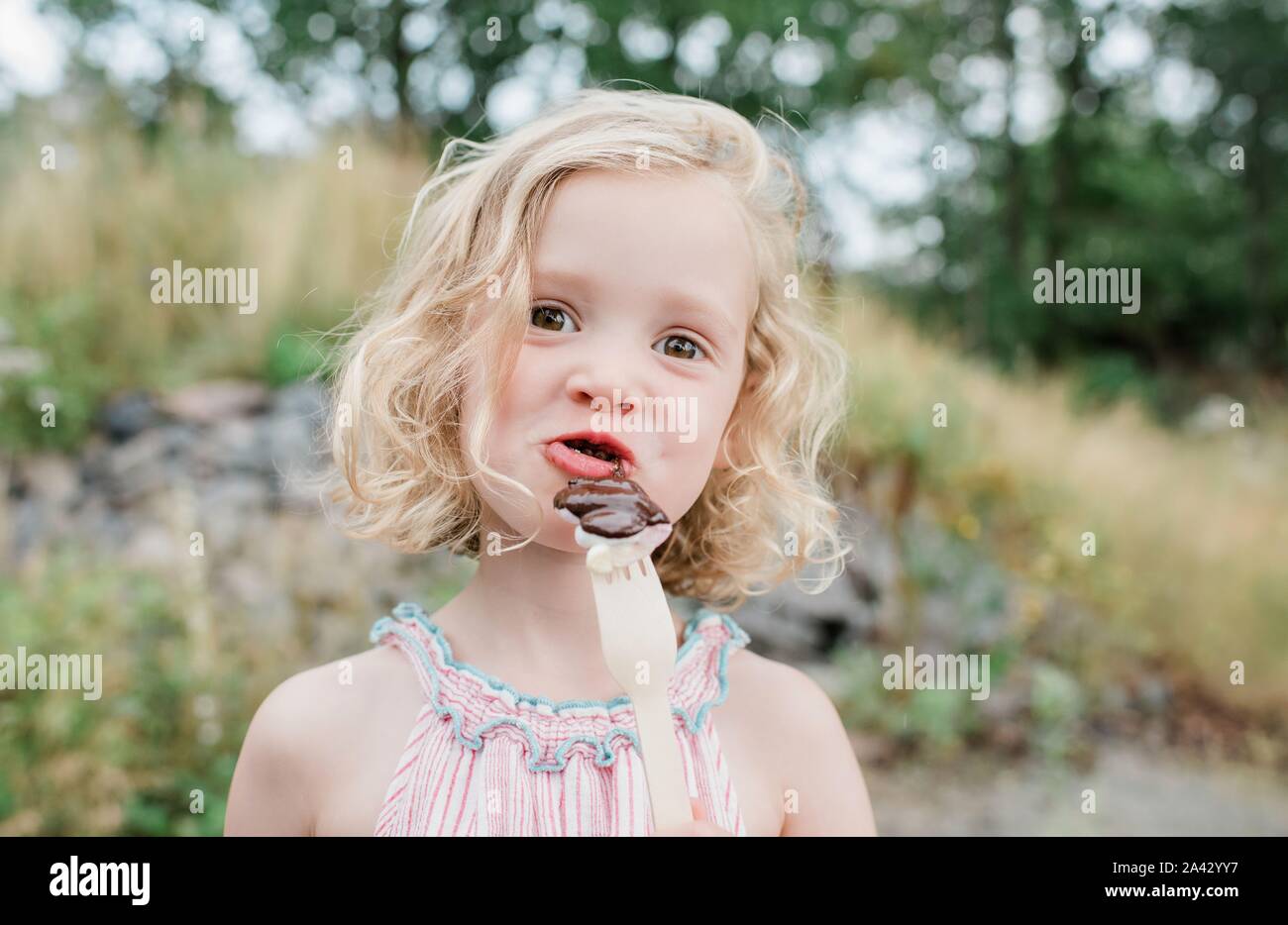 fun portrait of a young girl eating chocolate and marshmallows Stock Photo