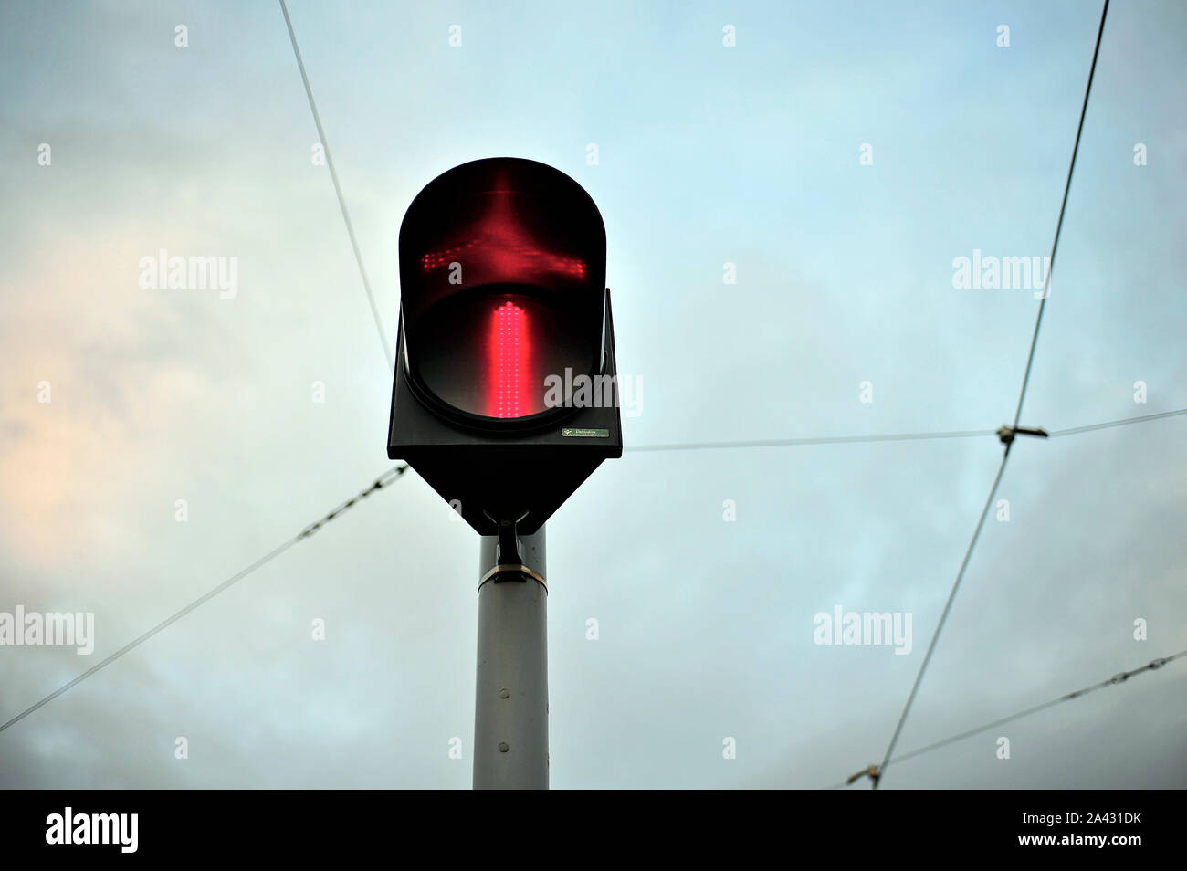 Tram signal against sky and overhead power lines at dusk in winter Stock Photo