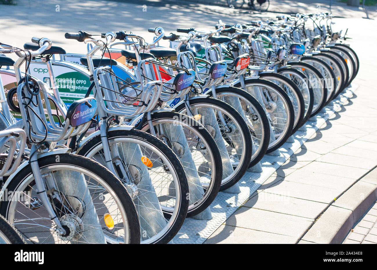 Warsaw, Poland: City bicycles parked in a row on bicycle parking - seen plaques with advertisements Stock Photo