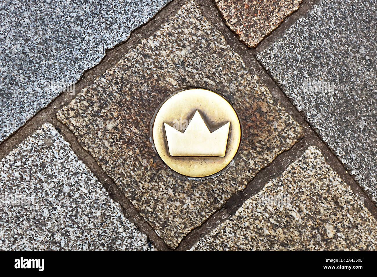 Top view of brass crown marker in cobblestone streets that shows location of the coronation walk, Bratislava, Slovakia. Old town Stock Photo