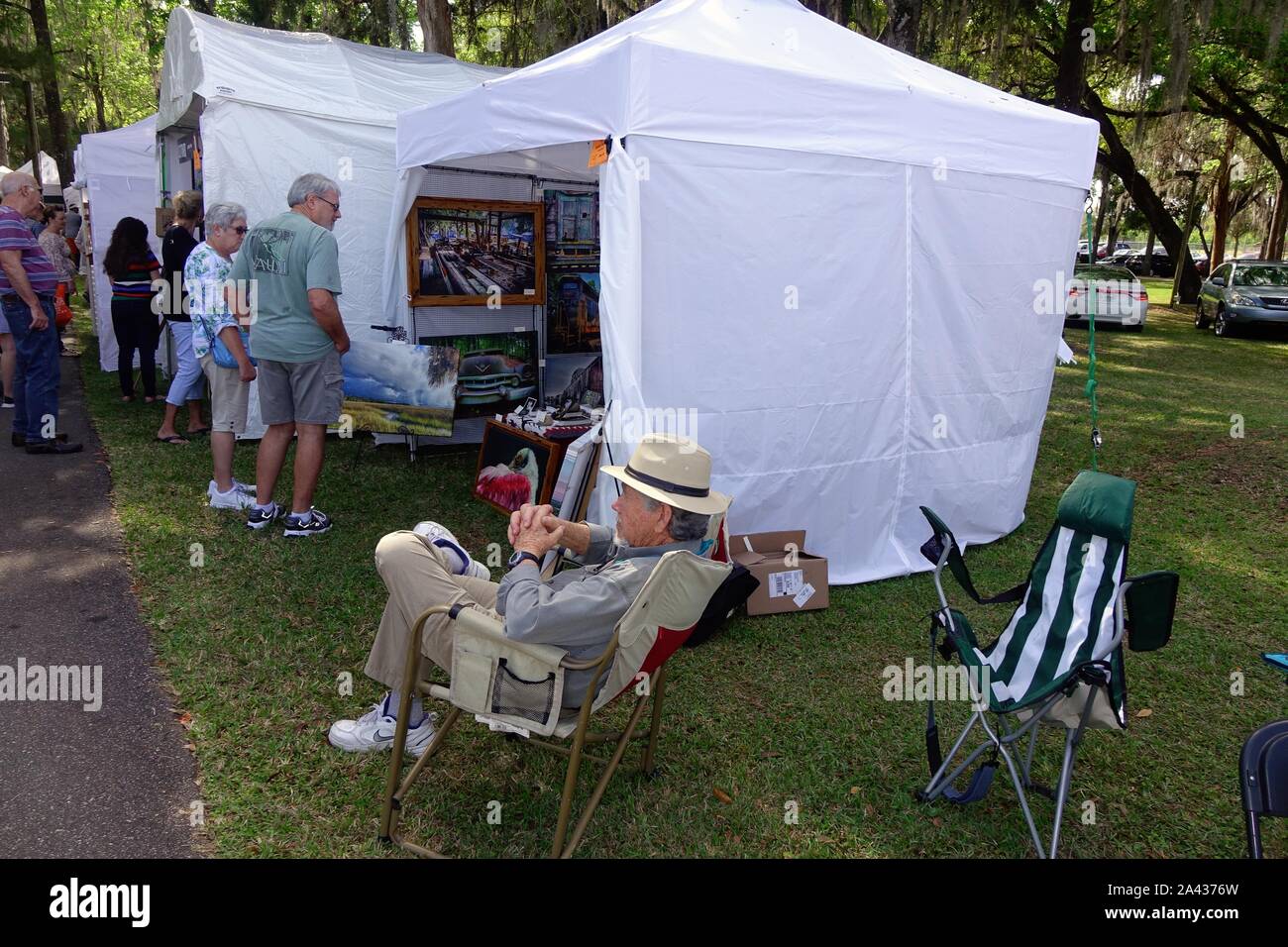 Artist watches as visitors look at his work. Art in the Park, Tom Varn Park, Brooksville, Flroida, 2019. Stock Photo