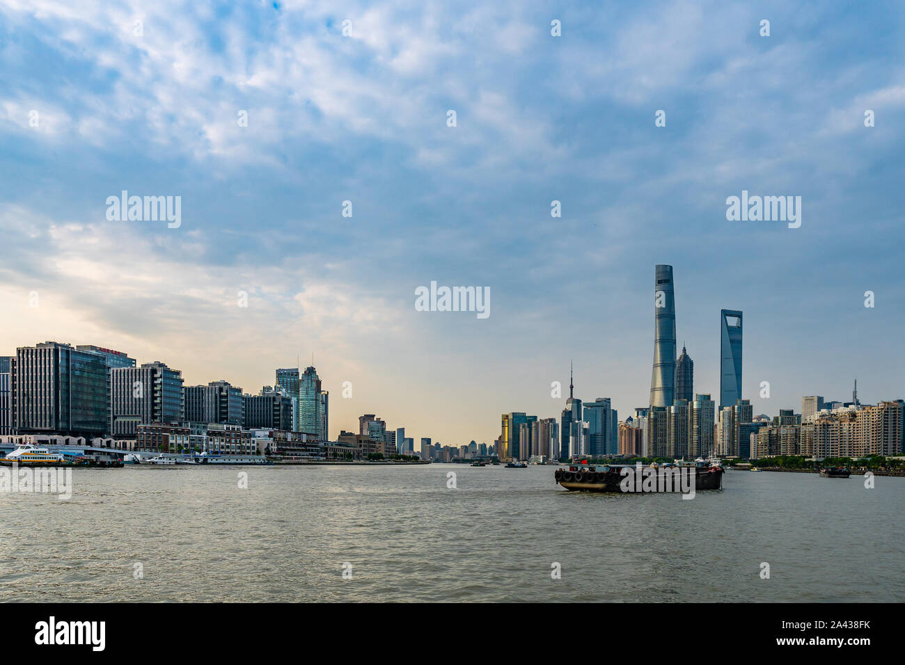 Shanghai Huangpu River Picturesque View of Cargo Freight Ships and Cityscape at Background During Sunset Stock Photo
