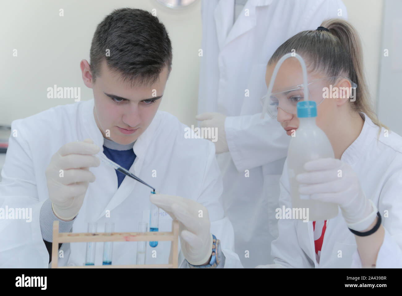 Group of young  scientists doing experiments in laboratory Stock Photo
