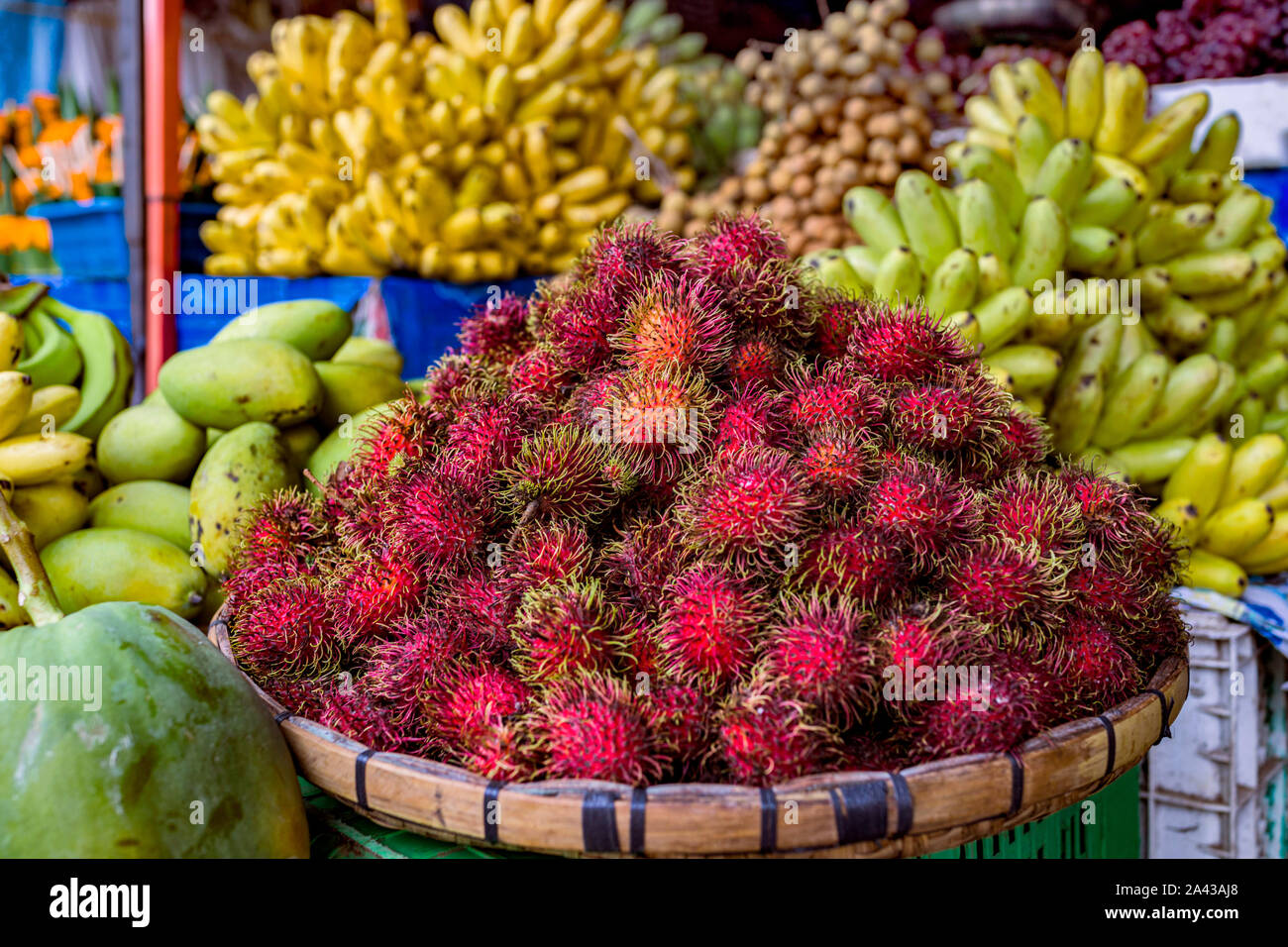 The most amazing and colourful fresh tropical fruit, including Rambutan, on sale in a street market in Luang Prabang in Laos. South East Asia Stock Photo