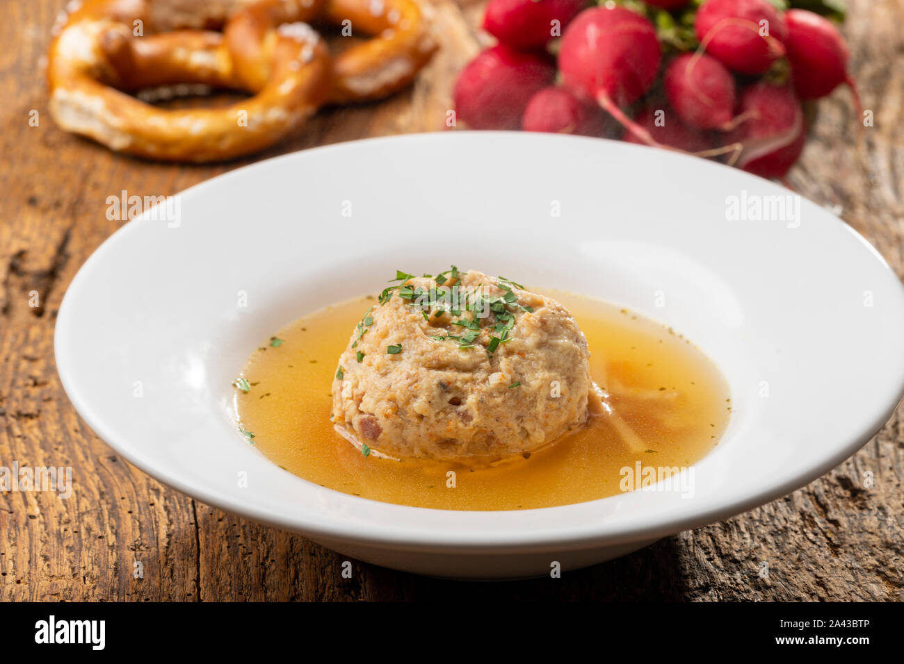 single speckknoedel in soup on wood Stock Photo