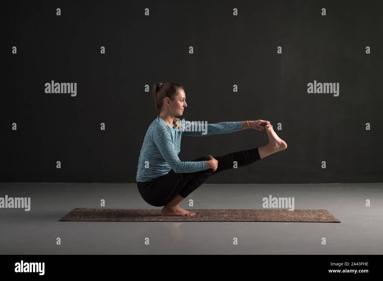 Young Beautiful Woman In Yoga Pose Balancing On One Leg Stock Photo Alamy