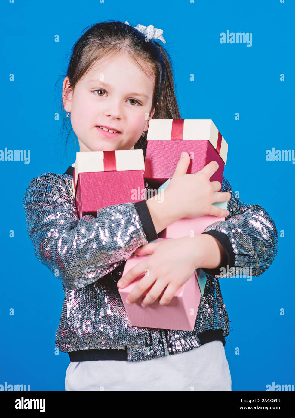 Black friday. Shopping day. Child carry lot gift boxes. Kids fashion. Surprise gift box. Birthday wish list. Special happens every day. Shop for what you want. Girl with gift boxes blue background. Stock Photo