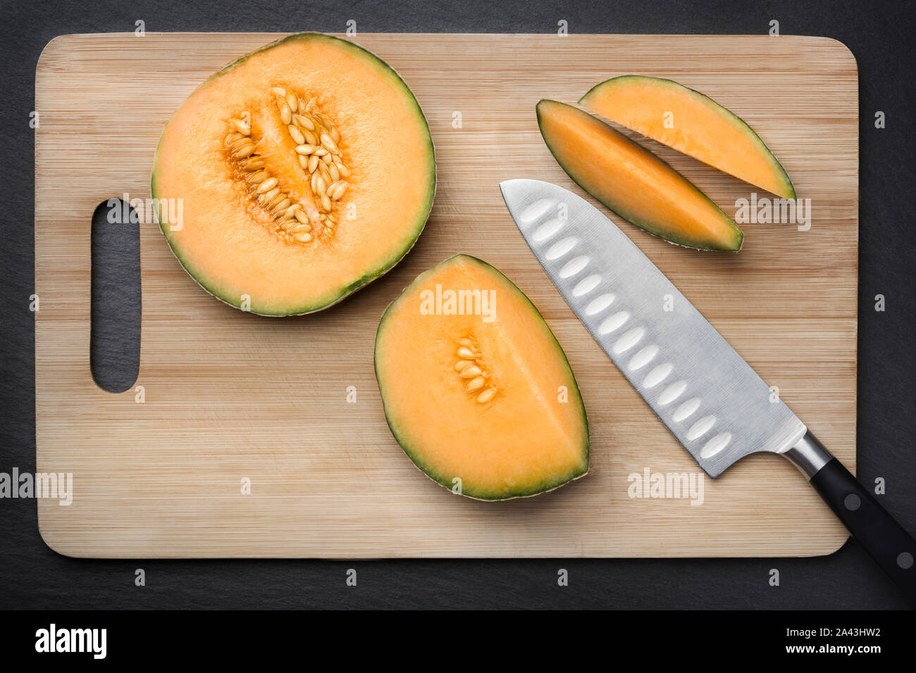 Cut sugar melon on a chopping board. Stock Photo