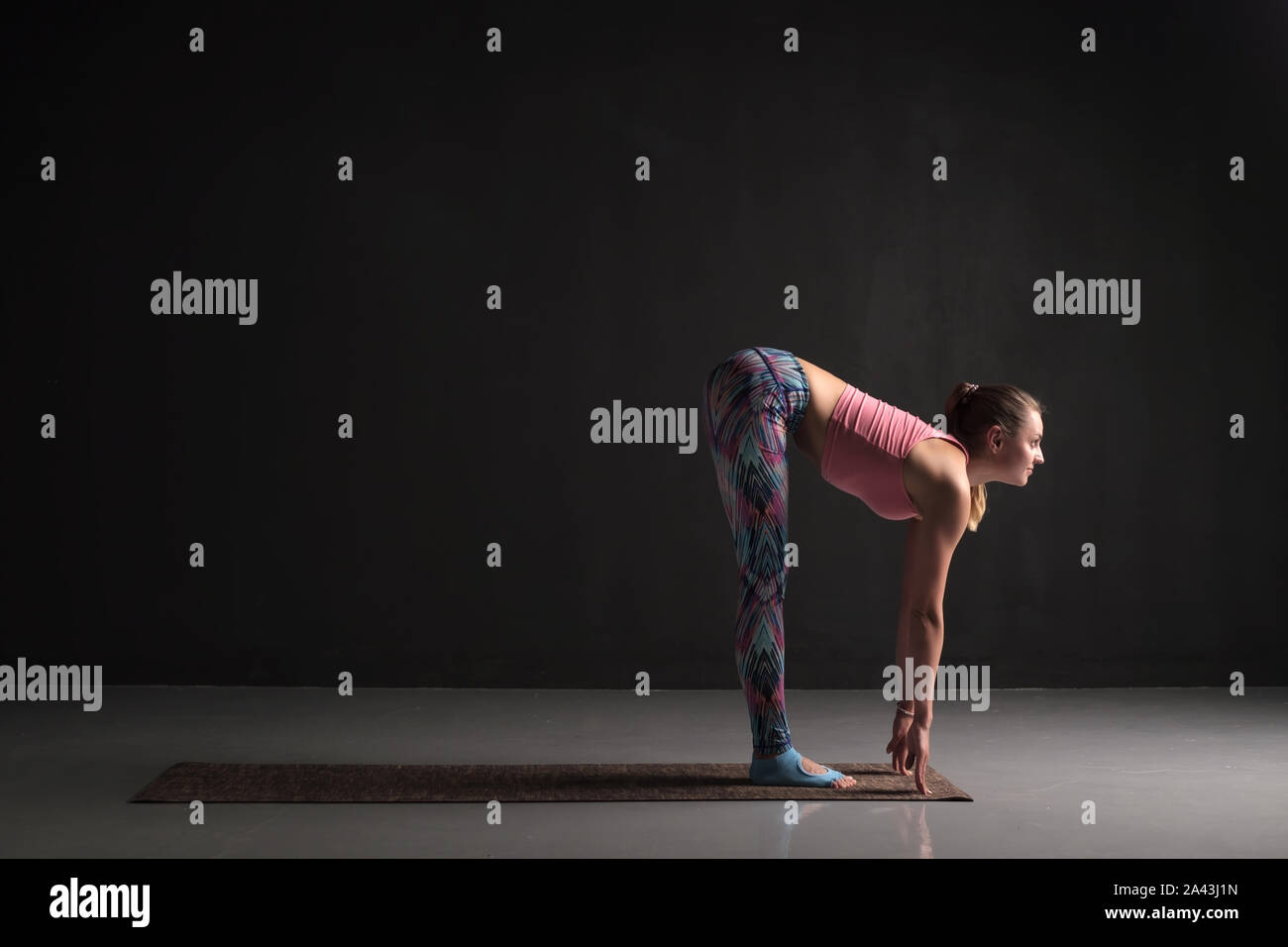 Woman is working out standing forward bend or uttanasana asana Stock Photo