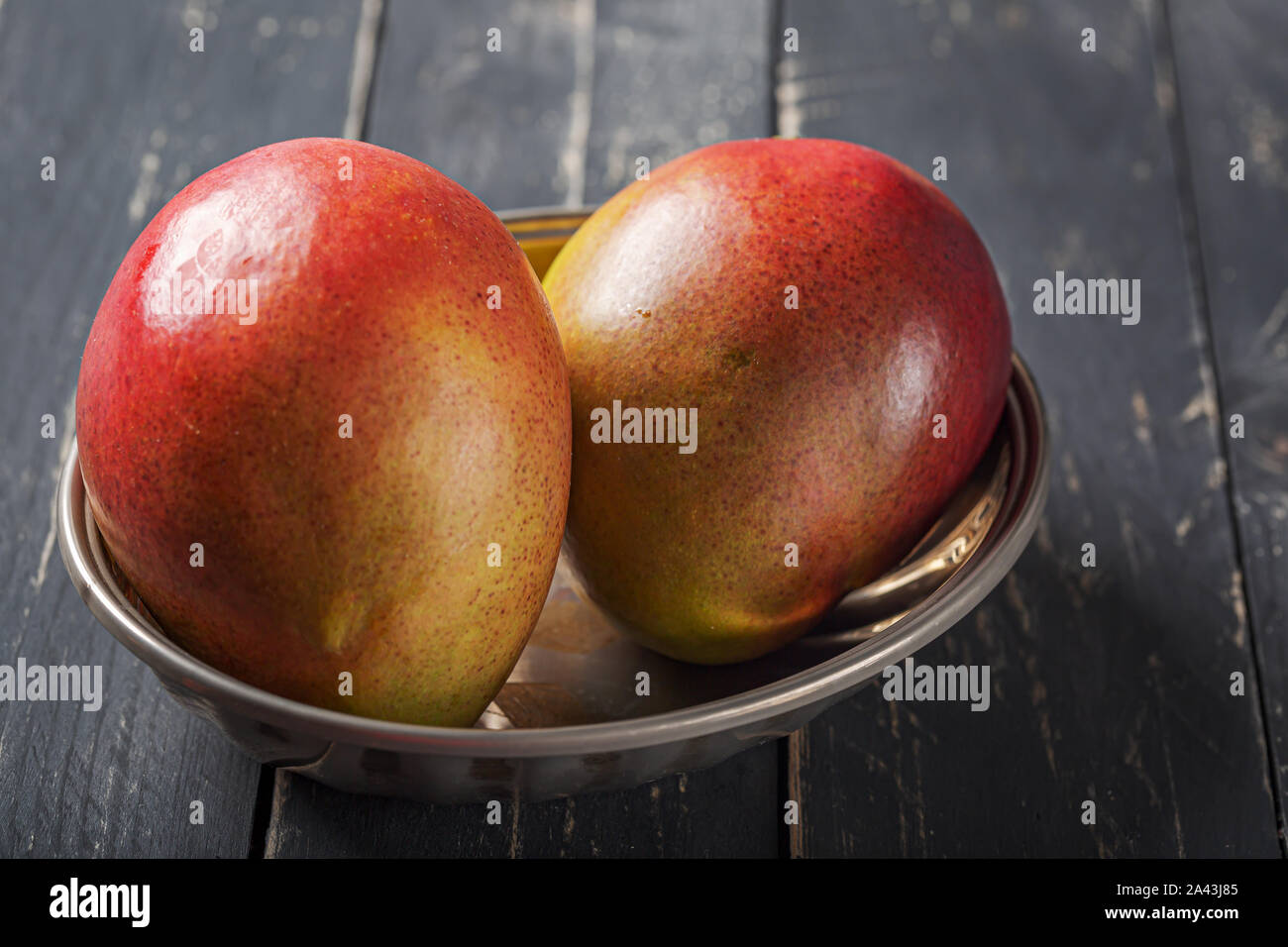 Mango fresh fruit on black wooden table. Stock Photo