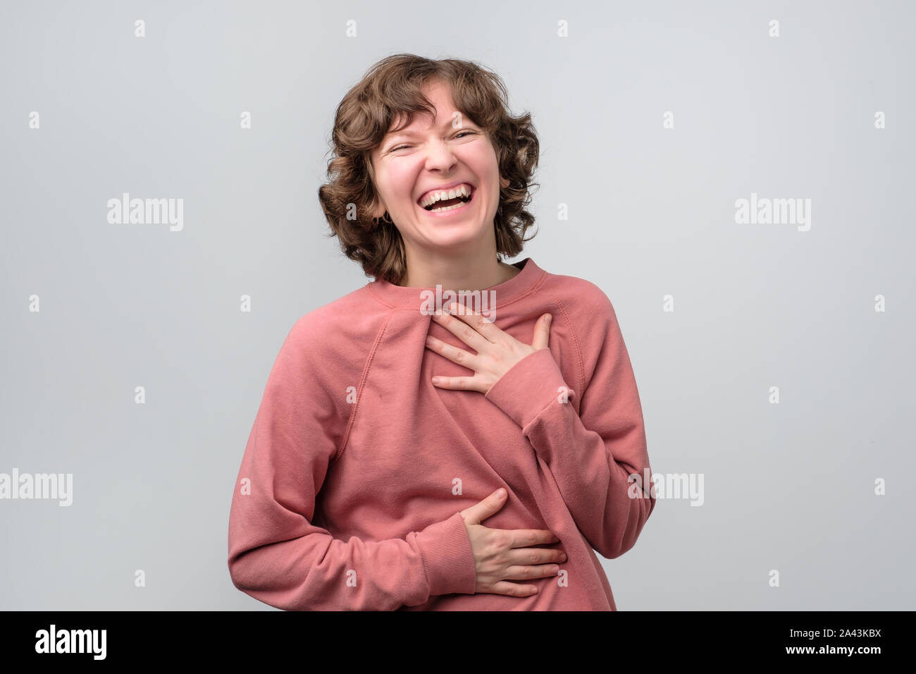 Laughing young casual woman with wide open mouth and closed eyes. Stock Photo