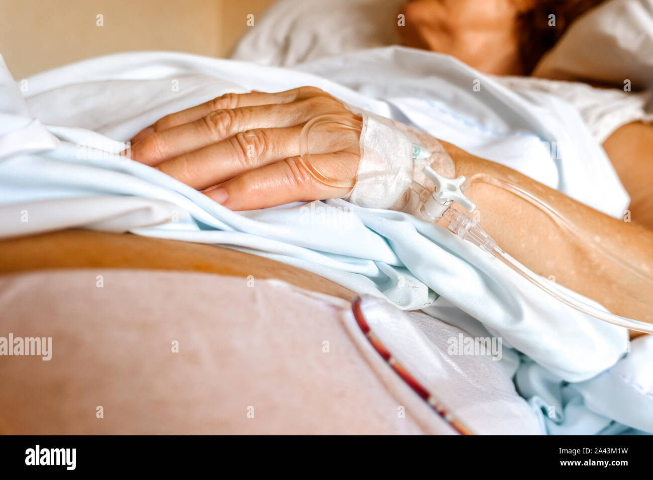 Intravenous cannula placed in the hand of an elderly patient for palliative care of a terminal patient. Stock Photo