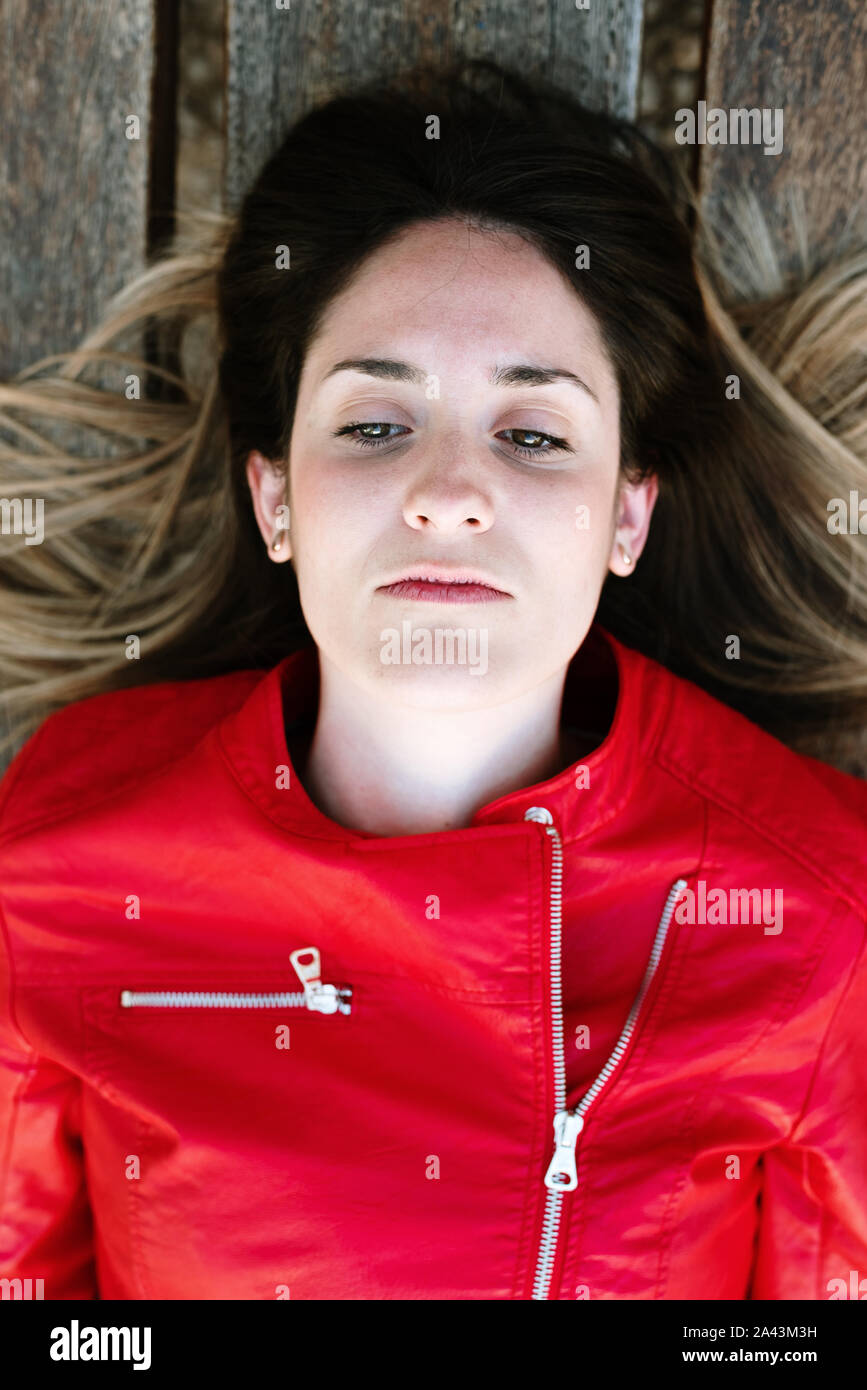 Portrait of young pretty woman, lying on her back resting pensive and sad Stock Photo Alamy